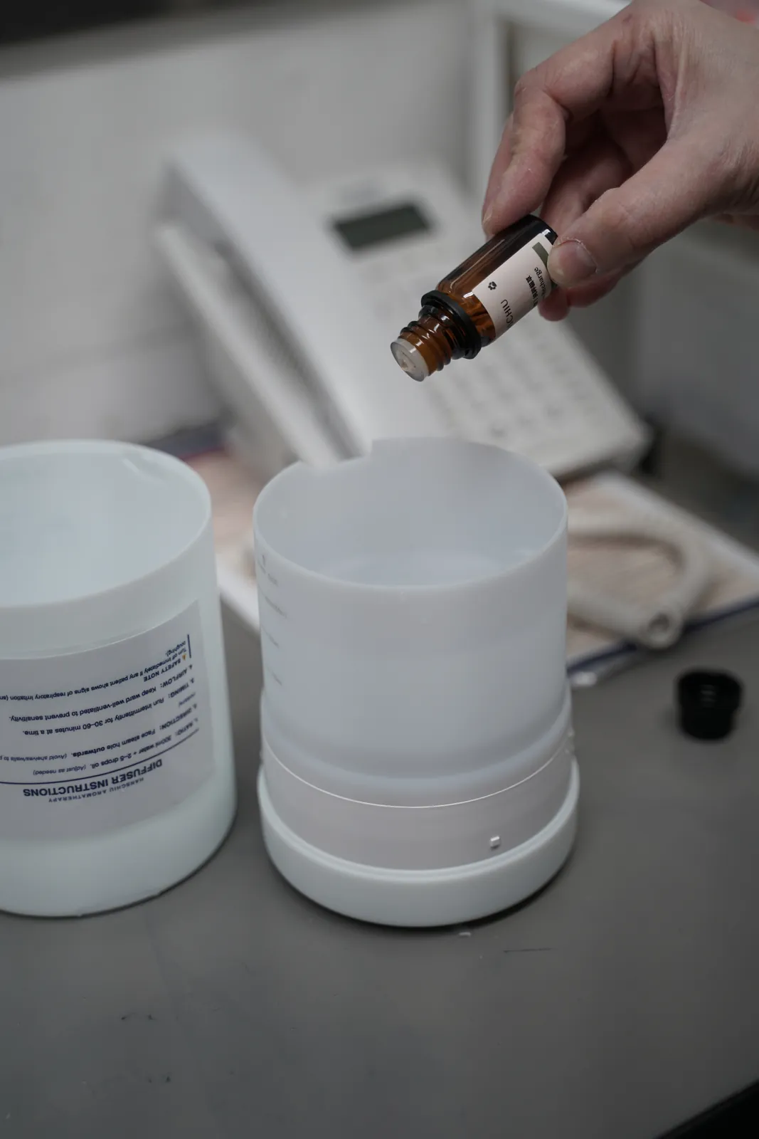 A team member adding HANSCHIU fragrance oil to a water-based aroma diffuser